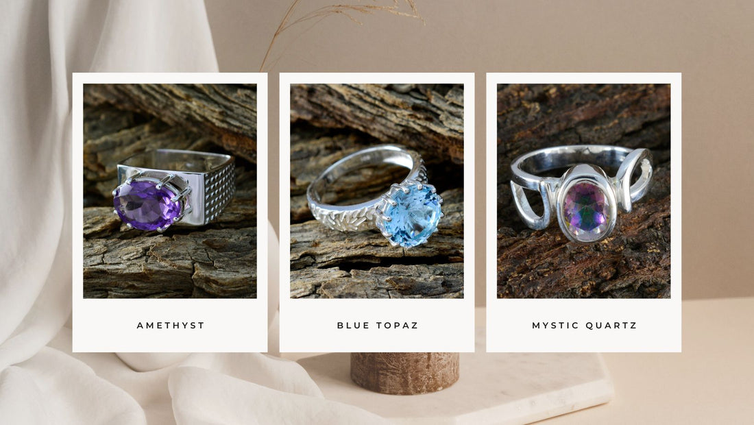 Collection of gemstone rings featuring Amethyst, Blue Topaz, and Mystic Quartz on a rustic background