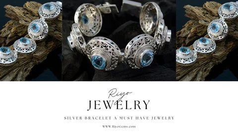Elegant silver bracelet must-have with intricate designs and blue gemstones on a rustic background
